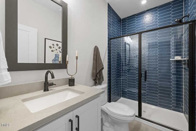 bathroom with vanity, an enclosed shower, and toilet