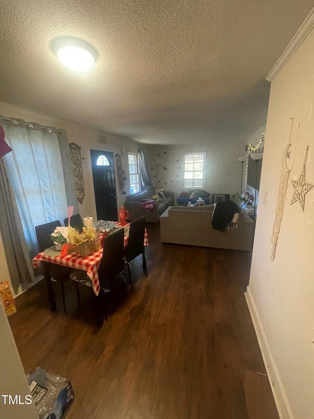 dining room with a textured ceiling, dark hardwood / wood-style flooring, and crown molding