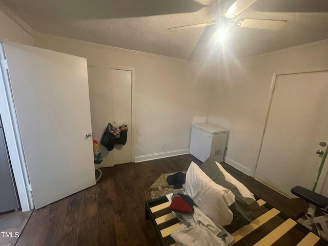 unfurnished bedroom with ceiling fan, dark hardwood / wood-style floors, crown molding, and a textured ceiling