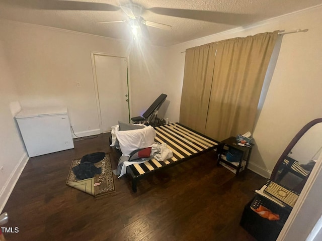 miscellaneous room featuring ceiling fan, dark hardwood / wood-style flooring, and a textured ceiling