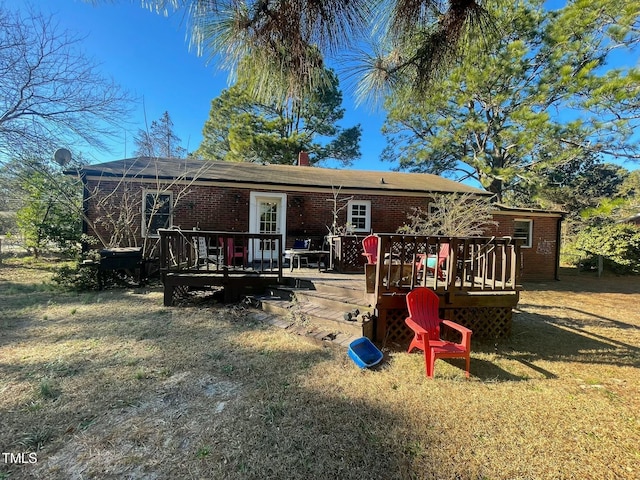 back of property with a yard and a wooden deck