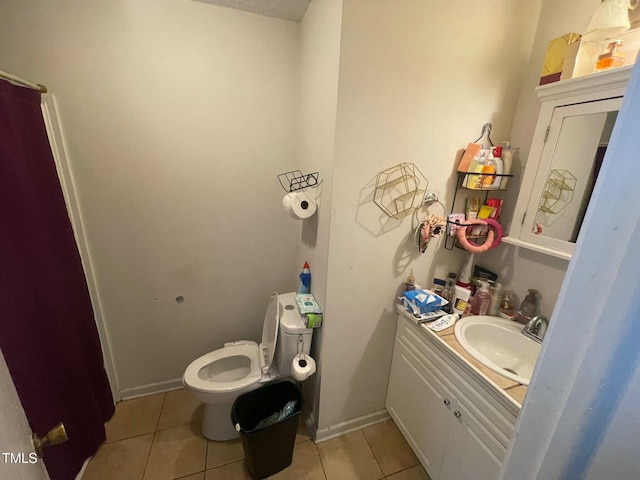 bathroom with toilet, tile patterned floors, and vanity