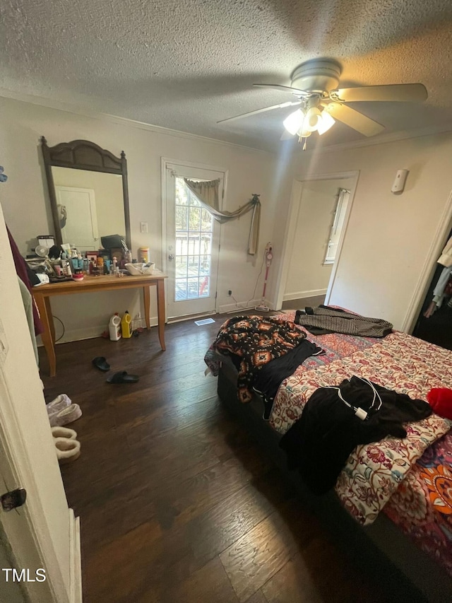 bedroom with ceiling fan, dark hardwood / wood-style floors, crown molding, and a textured ceiling