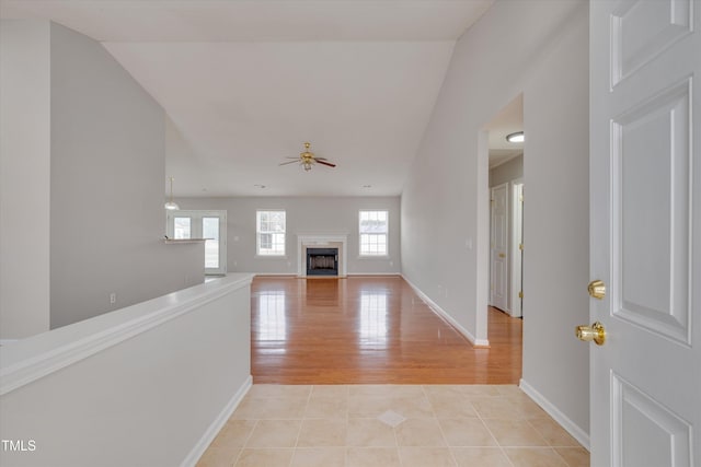 interior space with ceiling fan, a high end fireplace, and light tile patterned floors