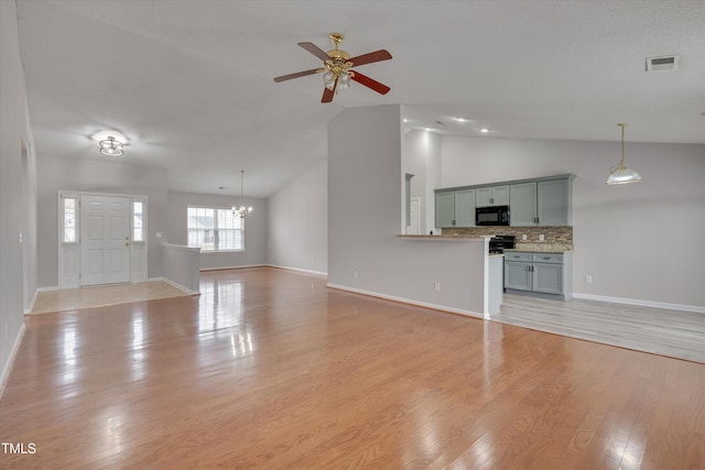 unfurnished living room featuring light wood-type flooring, ceiling fan with notable chandelier, and lofted ceiling