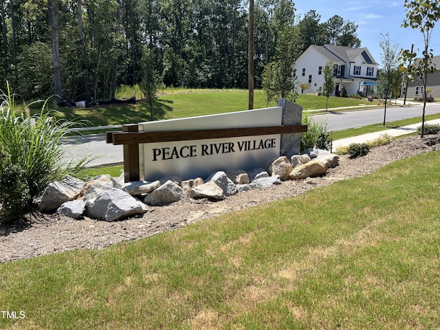 community / neighborhood sign featuring a yard