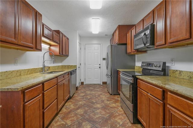255 Heartwood Dr, Raeford, NC 28376 - kitchen featuring appliances with stainless steel finishes, sink, light stone counters, and a textured ceiling