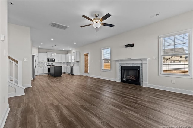 unfurnished living room featuring ceiling fan and dark hardwood / wood-style floors