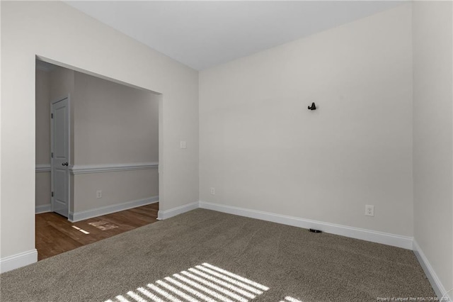 spare room featuring dark colored carpet