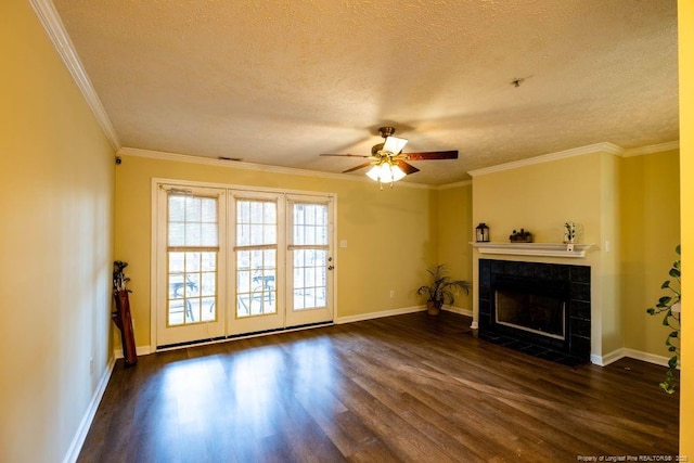 unfurnished living room with dark wood-type flooring, a textured ceiling, ornamental molding, and a tiled fireplace