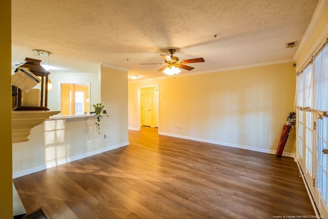 unfurnished living room with hardwood / wood-style flooring, a textured ceiling, crown molding, and plenty of natural light