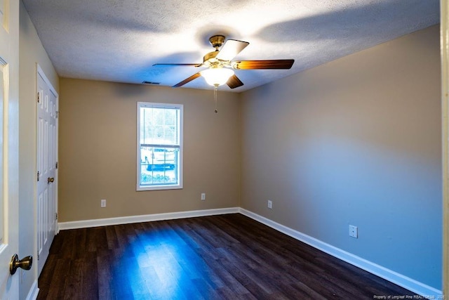 spare room featuring dark hardwood / wood-style flooring and a textured ceiling