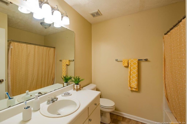 bathroom featuring toilet, vanity, and a textured ceiling