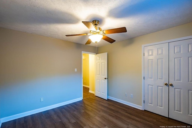 unfurnished bedroom featuring a textured ceiling, ceiling fan, a closet, and dark wood-type flooring