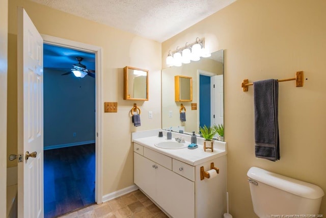 bathroom with ceiling fan, a textured ceiling, toilet, and vanity