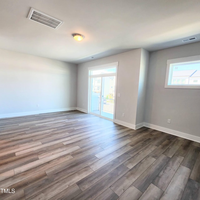 unfurnished room with plenty of natural light and wood-type flooring