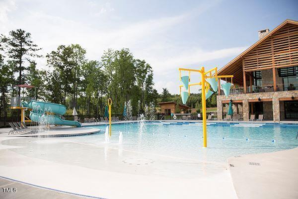 view of swimming pool with pool water feature and a water slide