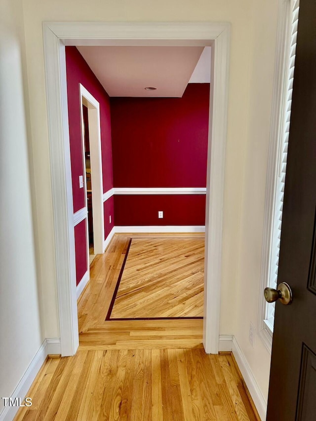 corridor with hardwood / wood-style flooring