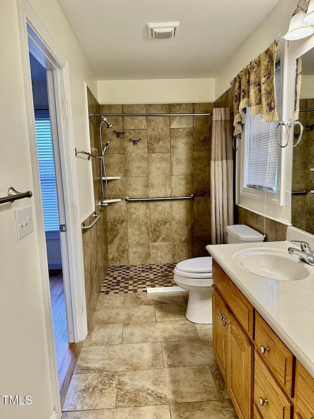 bathroom featuring toilet, a shower with shower curtain, and vanity