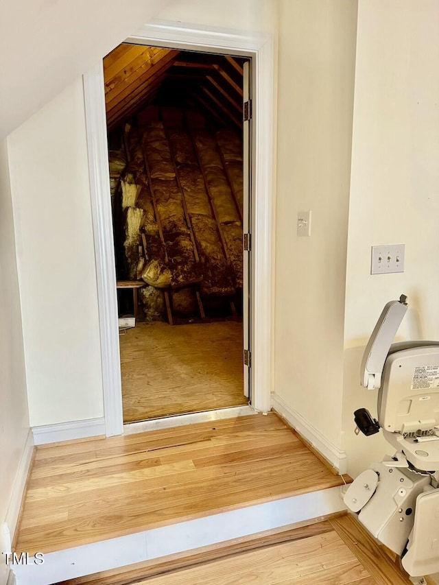 corridor with lofted ceiling and hardwood / wood-style flooring