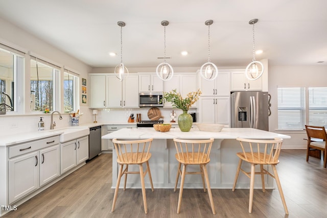 kitchen featuring white cabinetry, pendant lighting, stainless steel appliances, and a center island