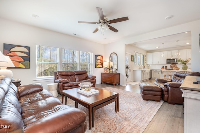 living room featuring ceiling fan and light hardwood / wood-style flooring