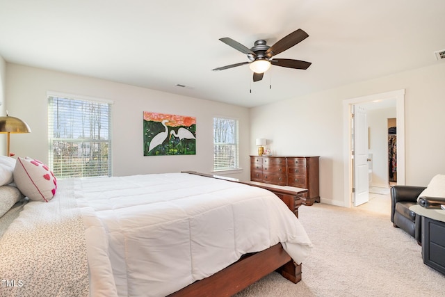 carpeted bedroom featuring ceiling fan and ensuite bath