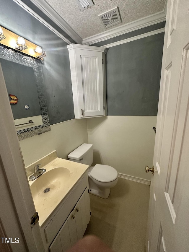 bathroom with toilet, vanity, crown molding, and a textured ceiling