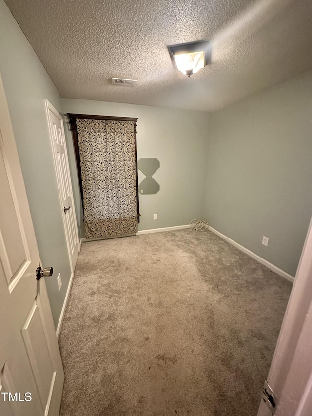 unfurnished bedroom with a textured ceiling and carpet flooring