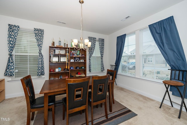 carpeted dining space with a notable chandelier