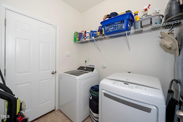 laundry area featuring washer and dryer and light tile patterned floors