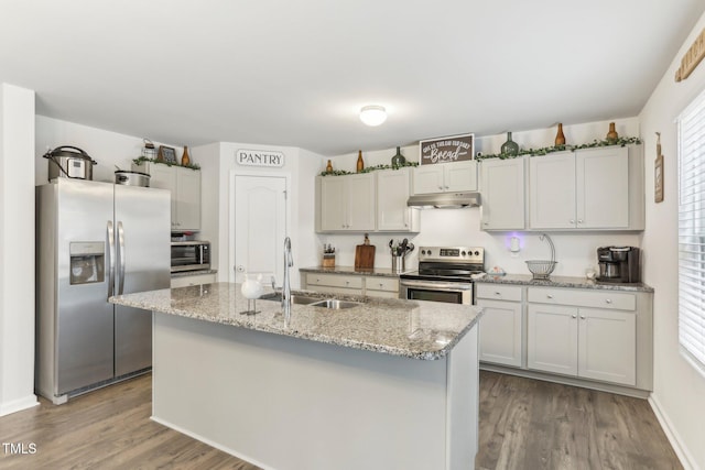 kitchen featuring white cabinetry, stainless steel appliances, sink, hardwood / wood-style flooring, and a center island with sink