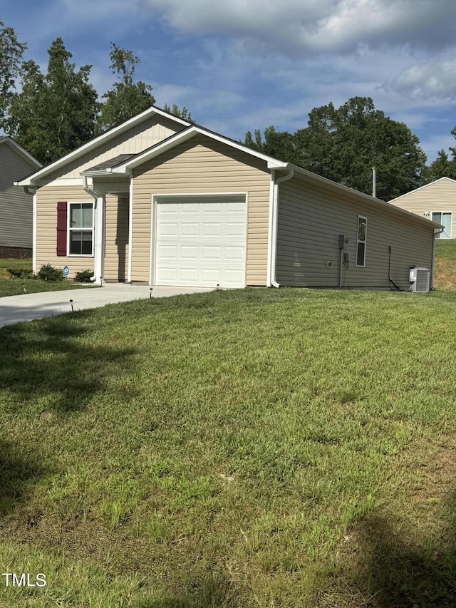 view of front of home with a front yard, central AC unit, and a garage