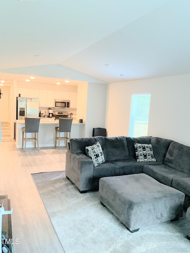 living room featuring vaulted ceiling and light hardwood / wood-style floors