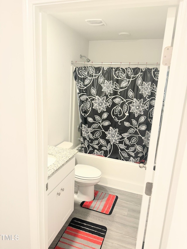 full bathroom featuring toilet, shower / tub combo, hardwood / wood-style flooring, and vanity