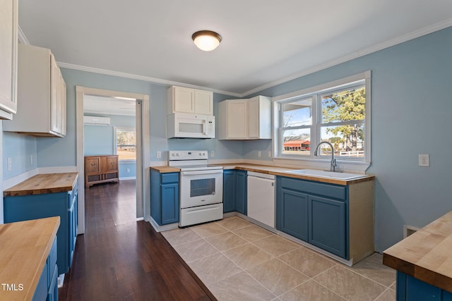 kitchen featuring white appliances, wooden counters, white cabinetry, sink, and blue cabinetry