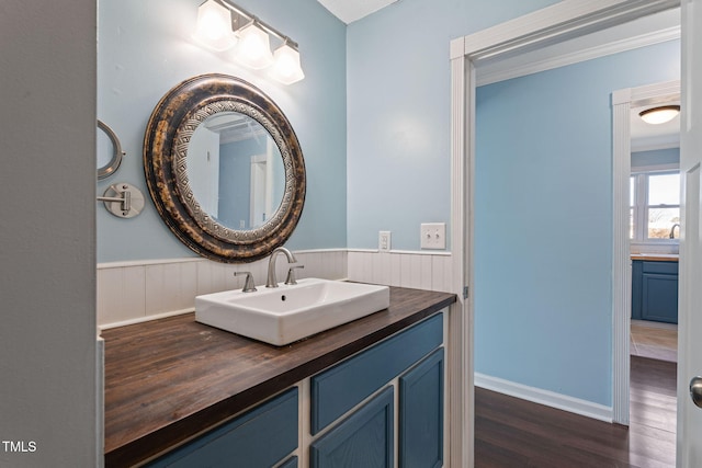 bathroom featuring crown molding, hardwood / wood-style floors, and vanity