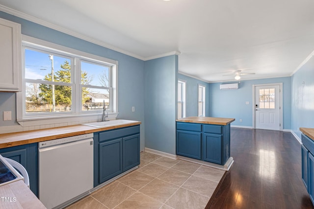 kitchen featuring an AC wall unit, sink, white dishwasher, blue cabinetry, and wood counters