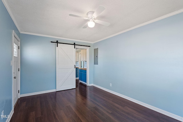 unfurnished bedroom with ceiling fan, a barn door, dark hardwood / wood-style flooring, and ornamental molding