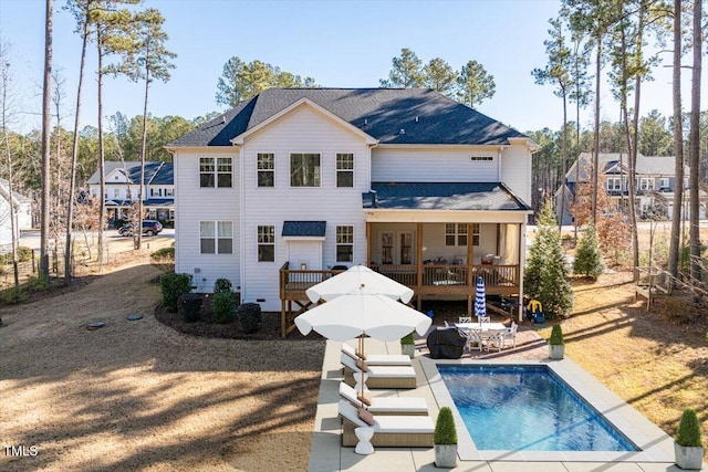 back of house featuring an outdoor pool, a deck, and a patio