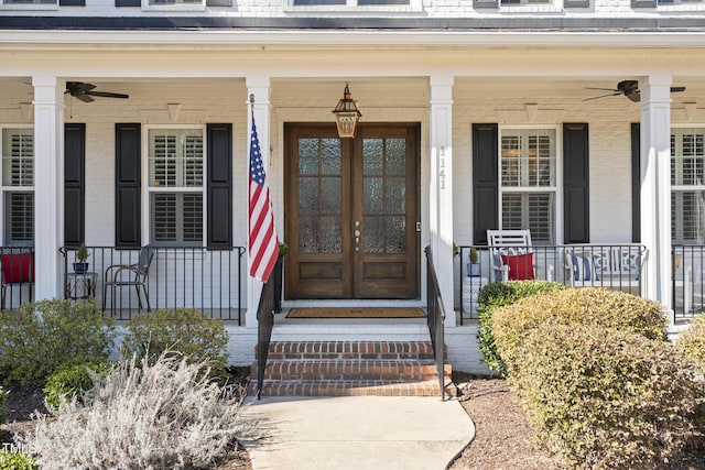 entrance to property with a porch, a ceiling fan, and brick siding