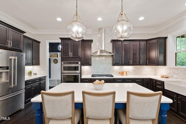 1141 Barley Stone Way, Raleigh, NC 27603 - kitchen with stainless steel appliances, wall chimney range hood, a kitchen island, light countertops, and ornamental molding