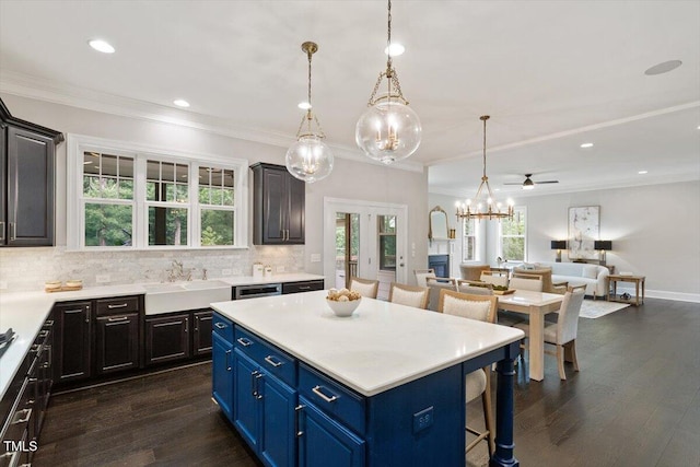 1141 Barley Stone Way, Raleigh, NC 27603 - kitchen featuring dark wood-style floors, light countertops, a kitchen breakfast bar, decorative backsplash, and crown molding