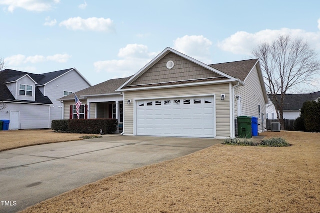 view of front of home with a garage, a front yard, and central air condition unit