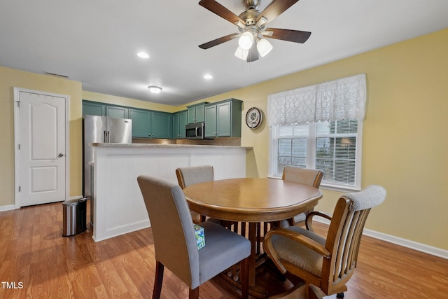 dining room with ceiling fan and light hardwood / wood-style floors