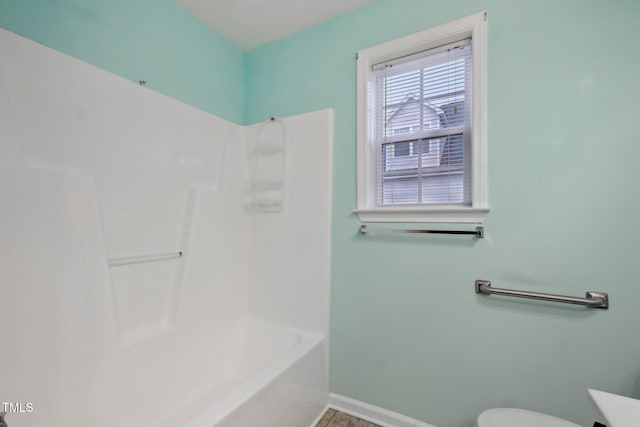 bathroom with shower / washtub combination and toilet