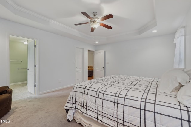 bedroom with ceiling fan, ornamental molding, a tray ceiling, and light carpet