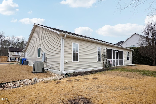 back of property with cooling unit and a lawn