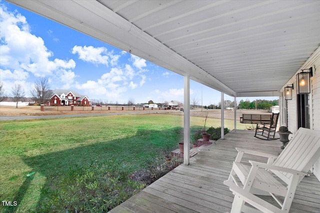 wooden terrace featuring covered porch and a yard