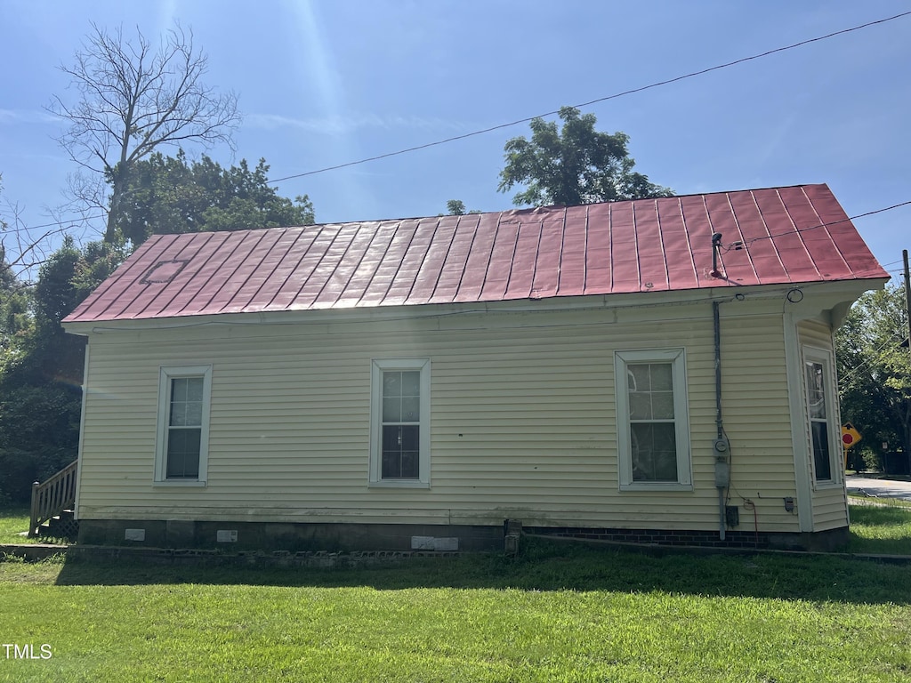 view of side of home with a yard